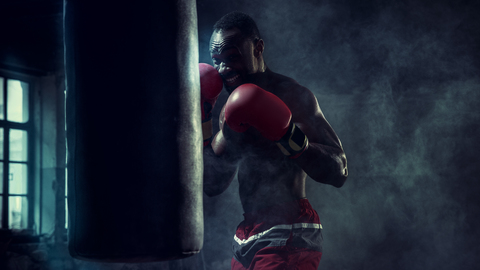 Hand of boxer over black background. Strength, attack and motion concept